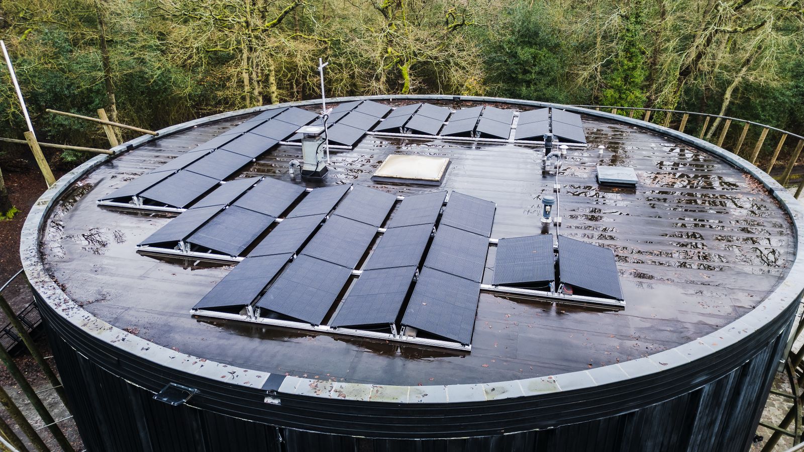 Dunkle Solarmodule auf einem runden Flachdach
